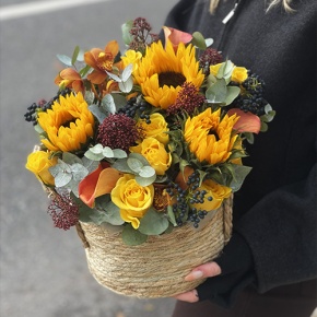 Композиция в сумке "Тональность" из подсолнухов, калл, ягод вибирнума, лимонных роз, скиммии и орхидеи в Лыткарино